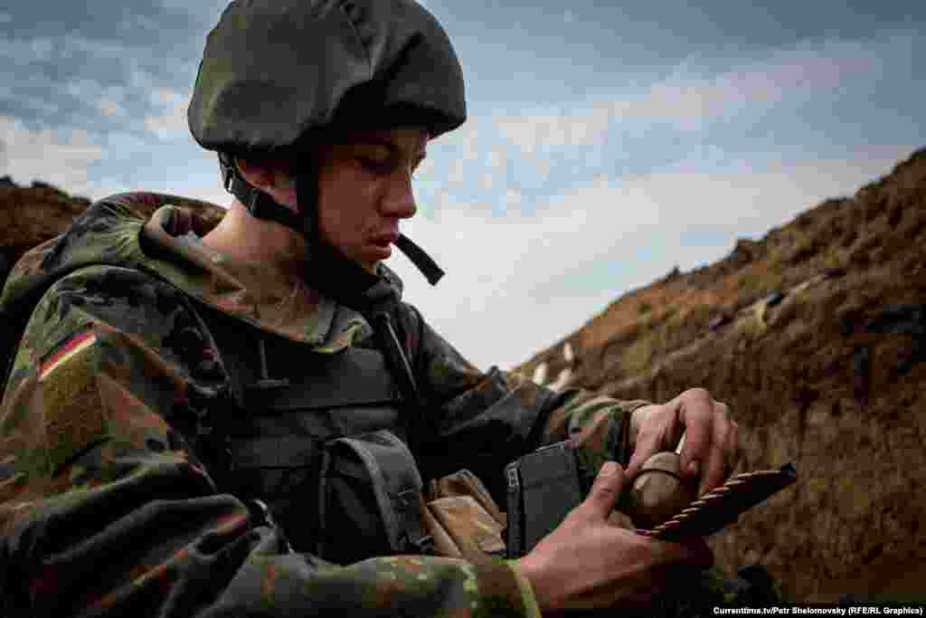 Украинский боец "Азова"  перезаряжает оружие. Село Широкино в Донецкой области, 18 апреля 2015