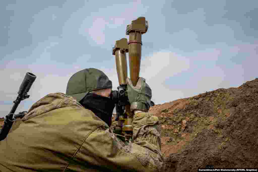 Боец "Азова" смотрит на вражеские позиции. Село Широкино в Донецкой области. 18 апреля 2015 