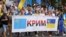 Шествие в Киеве с флагом крымских татар и украинским флагом
