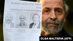 Борис Вишневский с фотографиями своих "двойников"